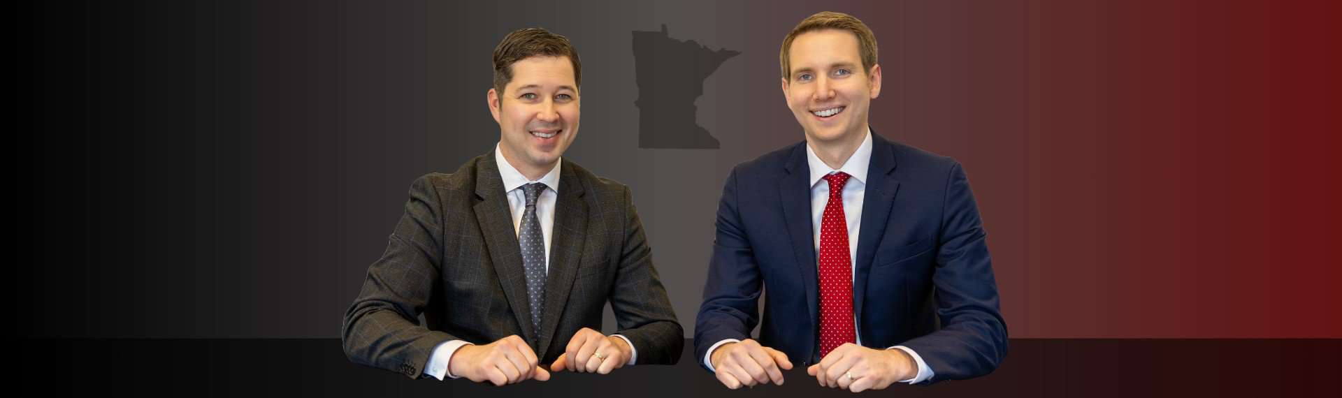 Criminal defense lawyers sitting at a table with the state of Minnesota outline between them