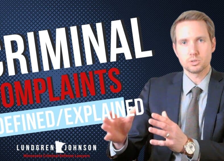 Criminal Lawyer Sitting in front of text that says criminal complaints defined/explained