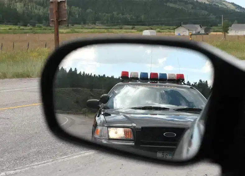 Criminal Defense Blog Image, cop car in rear view mirror